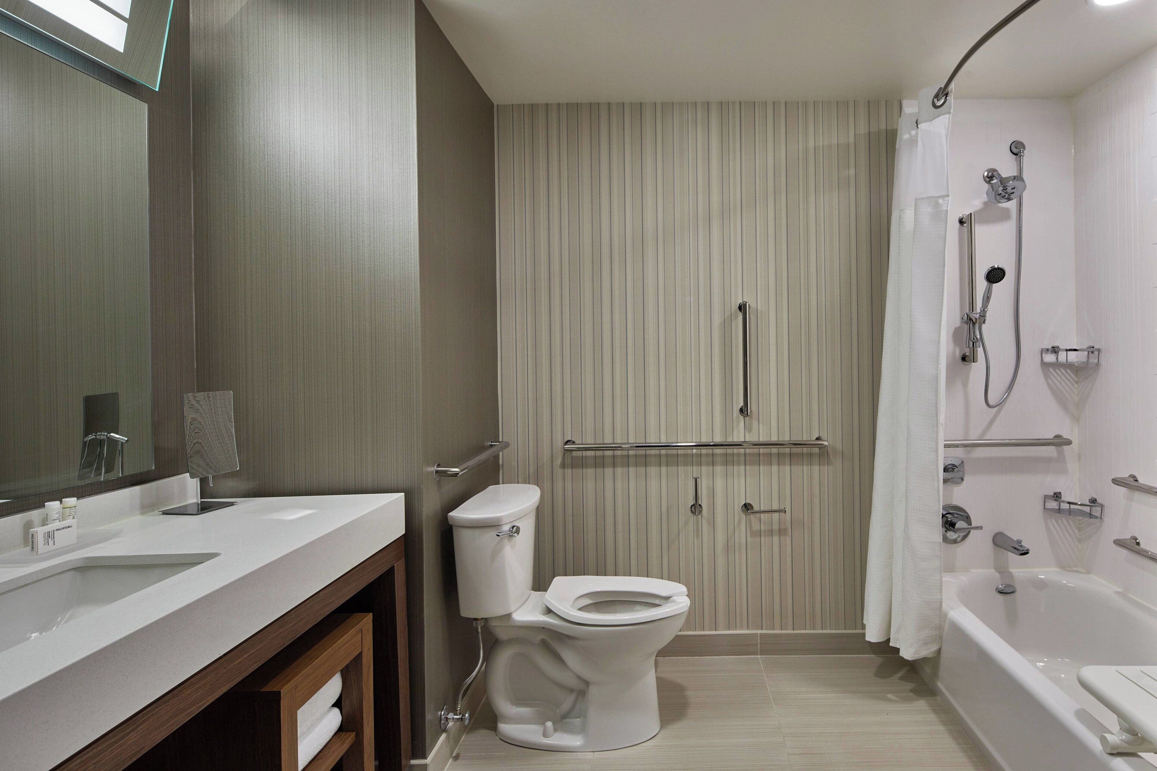 Un baño moderno con lavamanos, inodoro y ducha.