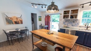 Cucina con tavolo in legno, sedie e lampadario.
