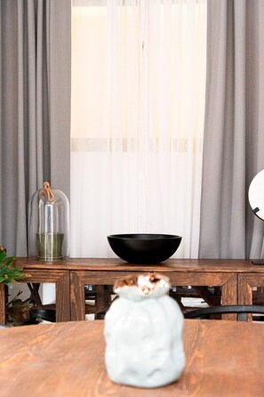 Una mesa de madera con una olla de cerámica blanca y un tazón negro.