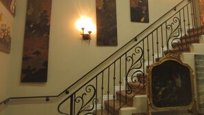 Un escalier orné de rampes noires et d’un miroir décoratif à sa base.