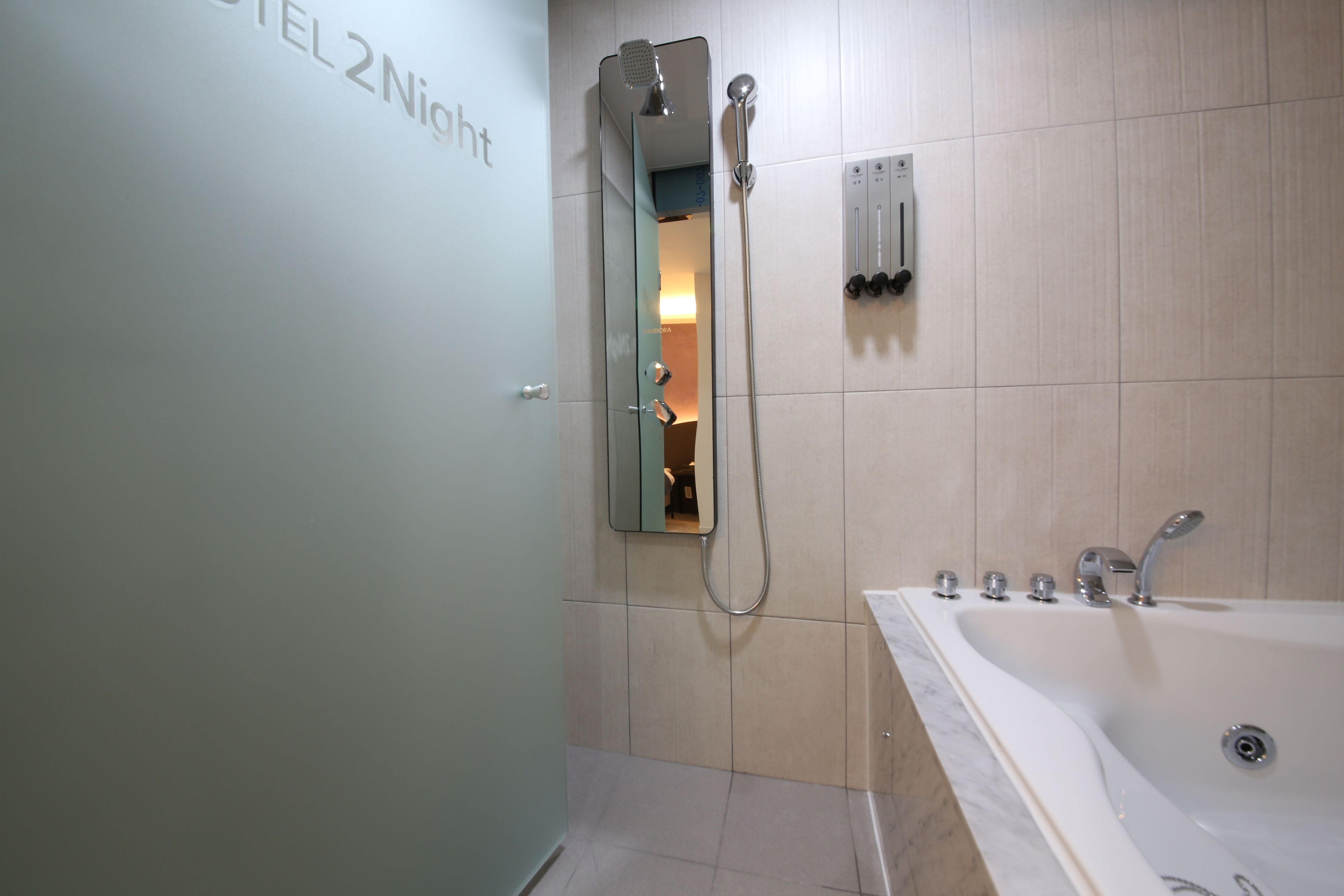 A modern bathroom with a shower, a bathtub, and a mirror.