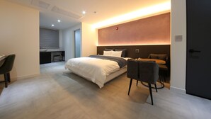 Ein modernes Schlafzimmer mit einem großen Bett, einem Schreibtisch und einer Essecke.