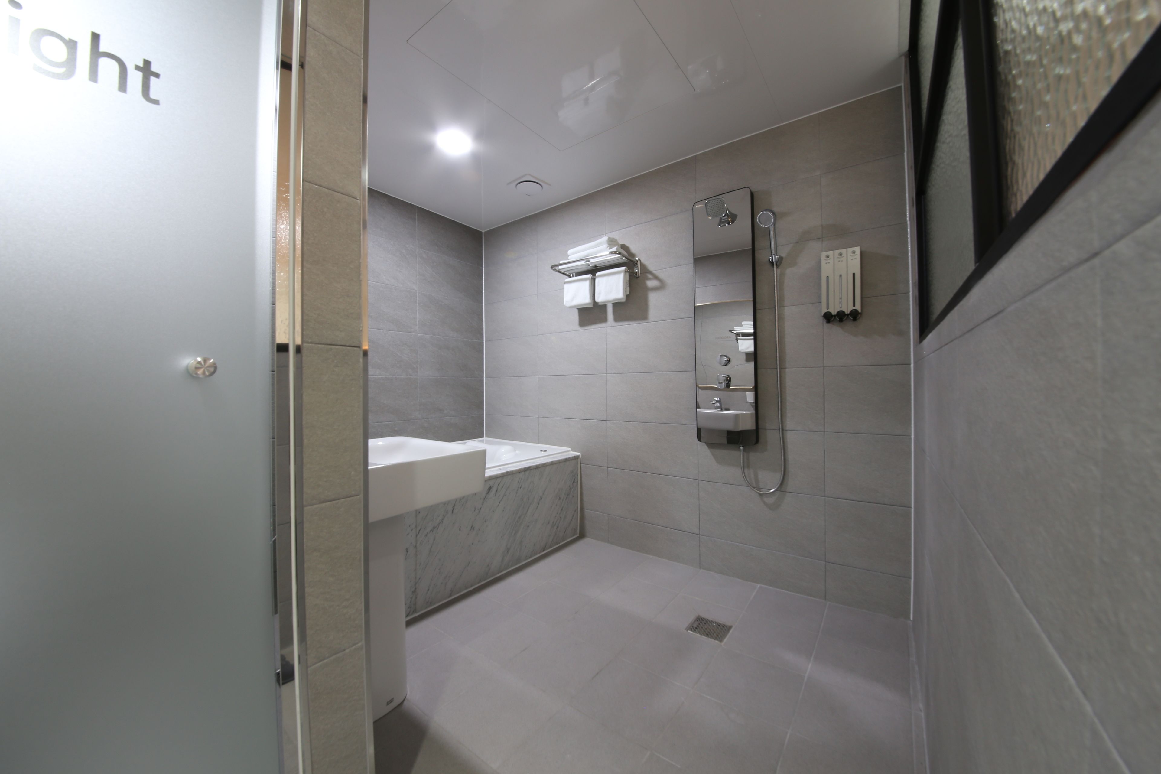 Ein modernes Badezimmer mit Dusche, Waschbecken und Spiegel.