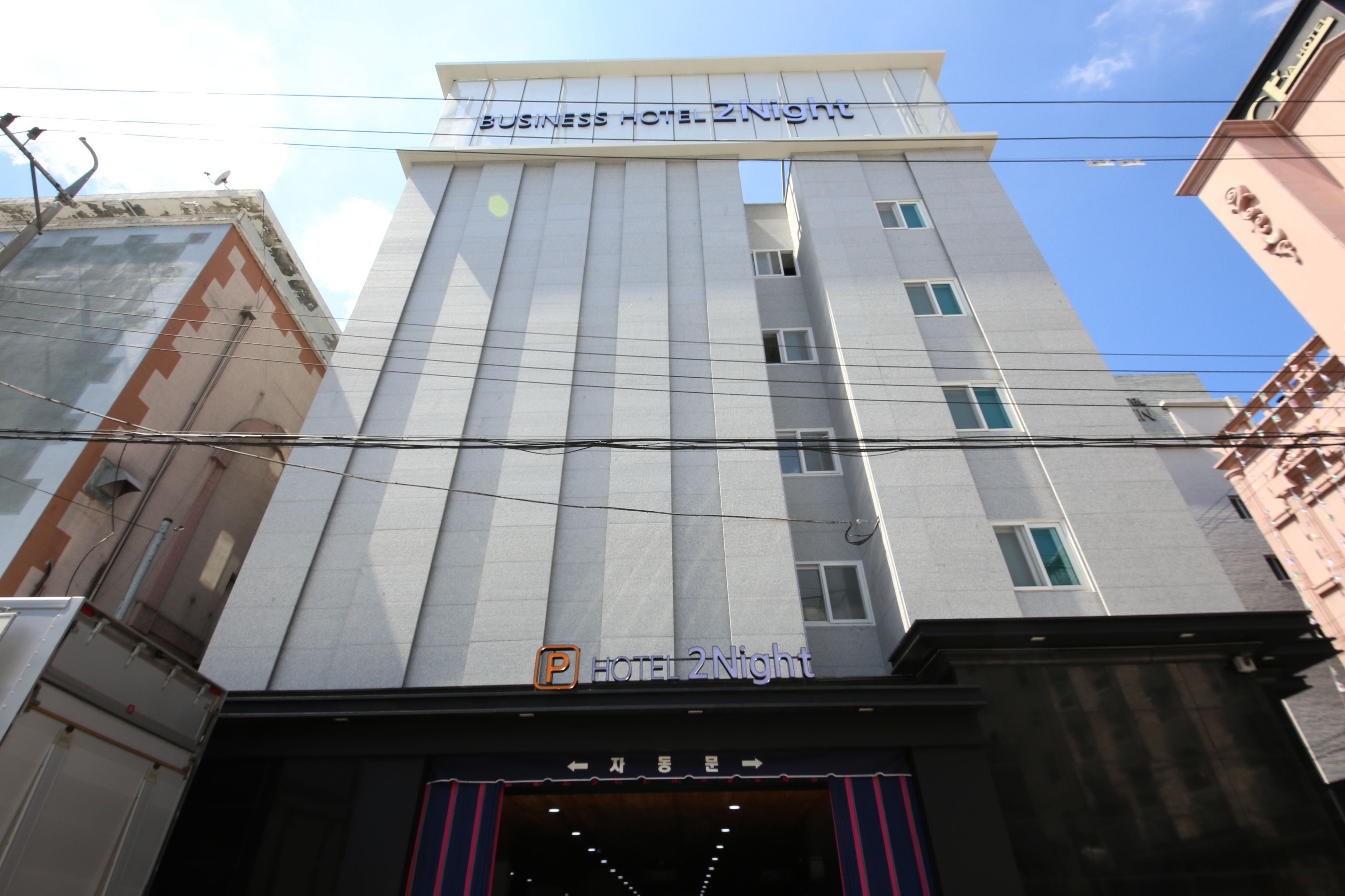 A business hotel with a modern facade, a prominent sign, and a clear entrance.