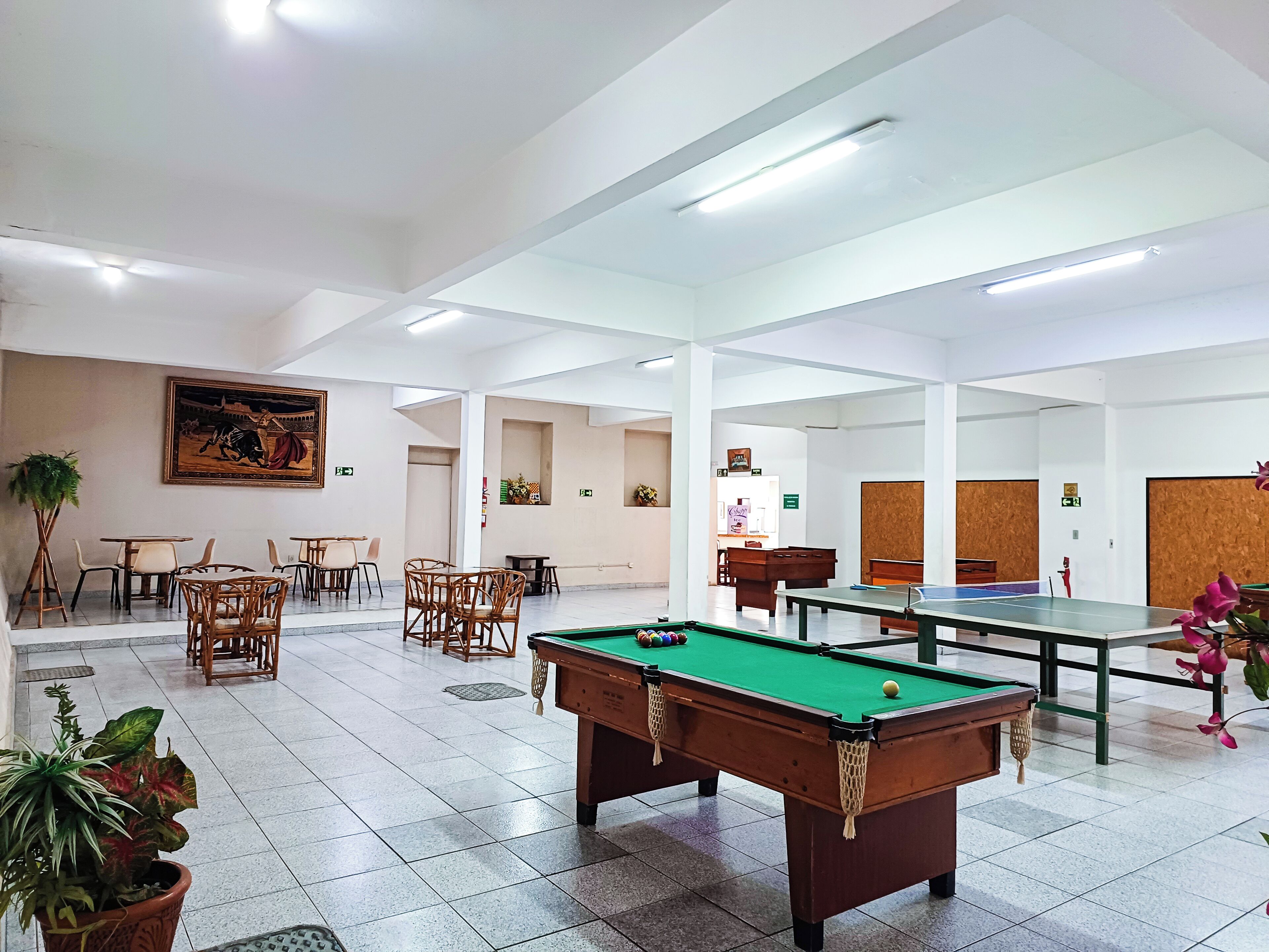 A spacious indoor area with a pool table, billiards, and seating arrangements.