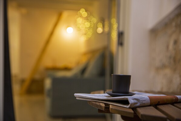 A wooden table with a cup and a menu.