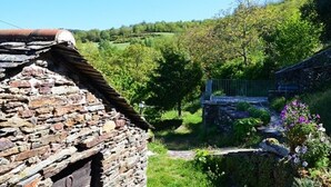 A rustic stone building with a sloped roof, surrounded by lush greenery and a clear blue sky. - Gîte in the heart of the Lozère Cévennes (La Falguière)