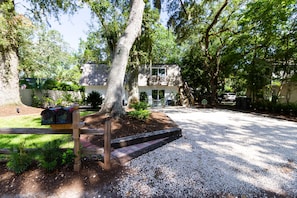 residence with a serene atmosphere, surrounded by mature trees and a secure wooden fence.