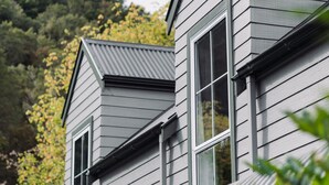 A modern house with a sloped roof and large windows. - Maruia River Retreat (Shenandoah)