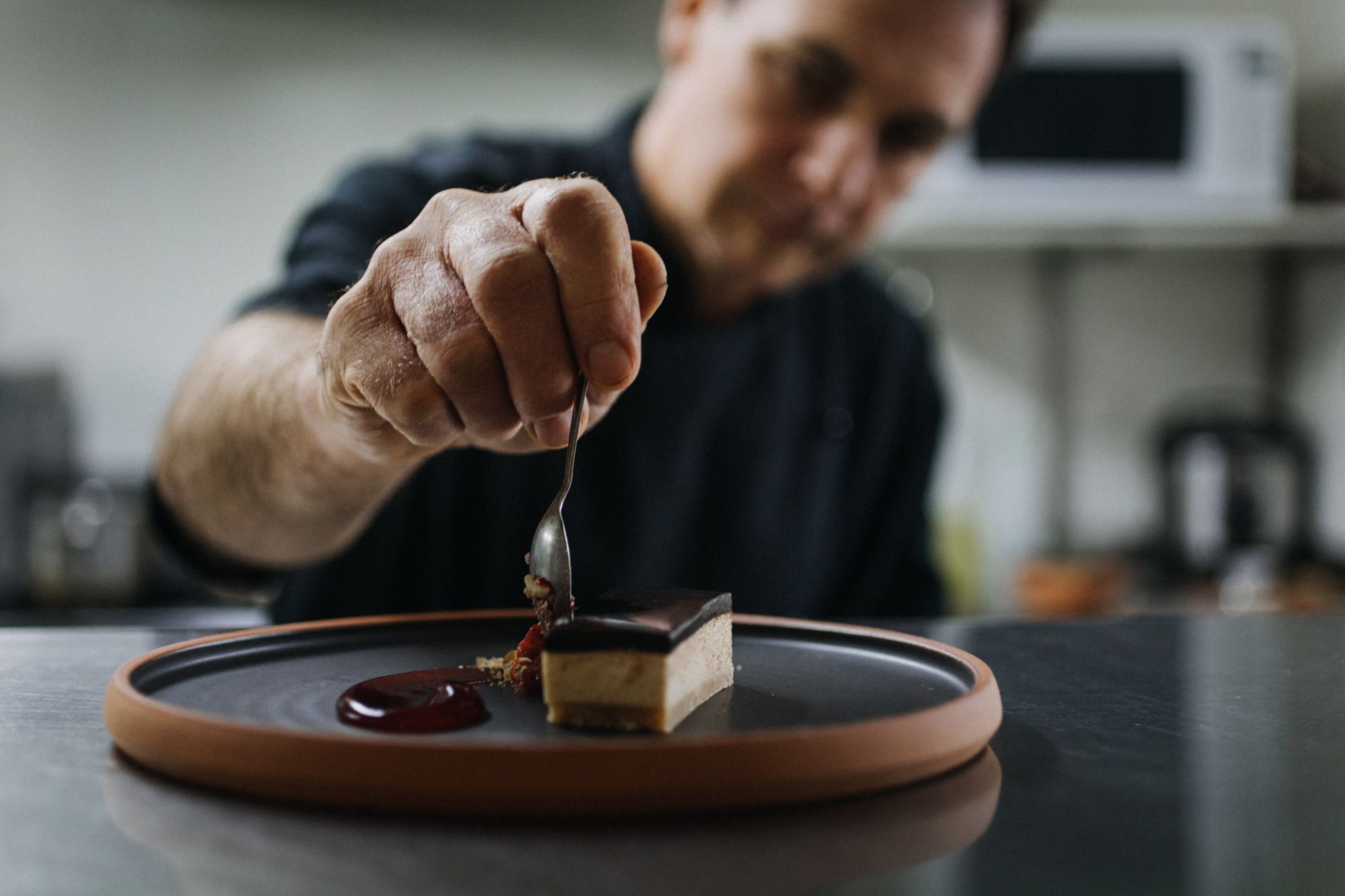 Una persona sosté una cullera sobre un postre a la plat.