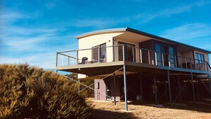 A modern two-story house with a balcony and a covered patio area. - Freycinet Dream (Coles Bay)