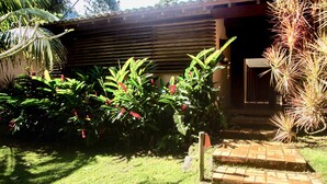 A garden with a wooden structure, a brick pathway, and various plants. - Beautiful house in Ilhabela (Ilhabela)