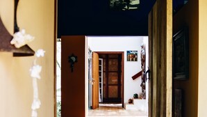 A hallway with a tiled floor leading to a wooden door. - Beautiful house in Ilhabela (Ilhabela)