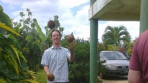 A man standing in a grassy area with a car parked in the background. - Green Lodge Holiday Homes (Nuku'alofa)