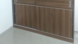 Un armario con dos puertas y un panel corredero, con acabados de madera y tiradores metálicos.