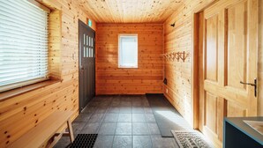 Un interior de madera con un banco, una puerta y una ventana.