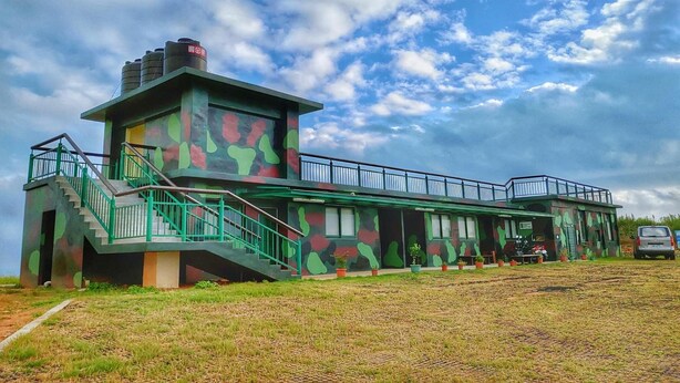 Un edificio con fachada camuflada, una escalera y un balcón.