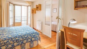 Ein Schlafzimmer mit einem Bett, einem Schreibtisch, einem Stuhl und einem Fenster.
