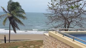 Una playa cerca, sillas reclinables de playa, toallas de playa