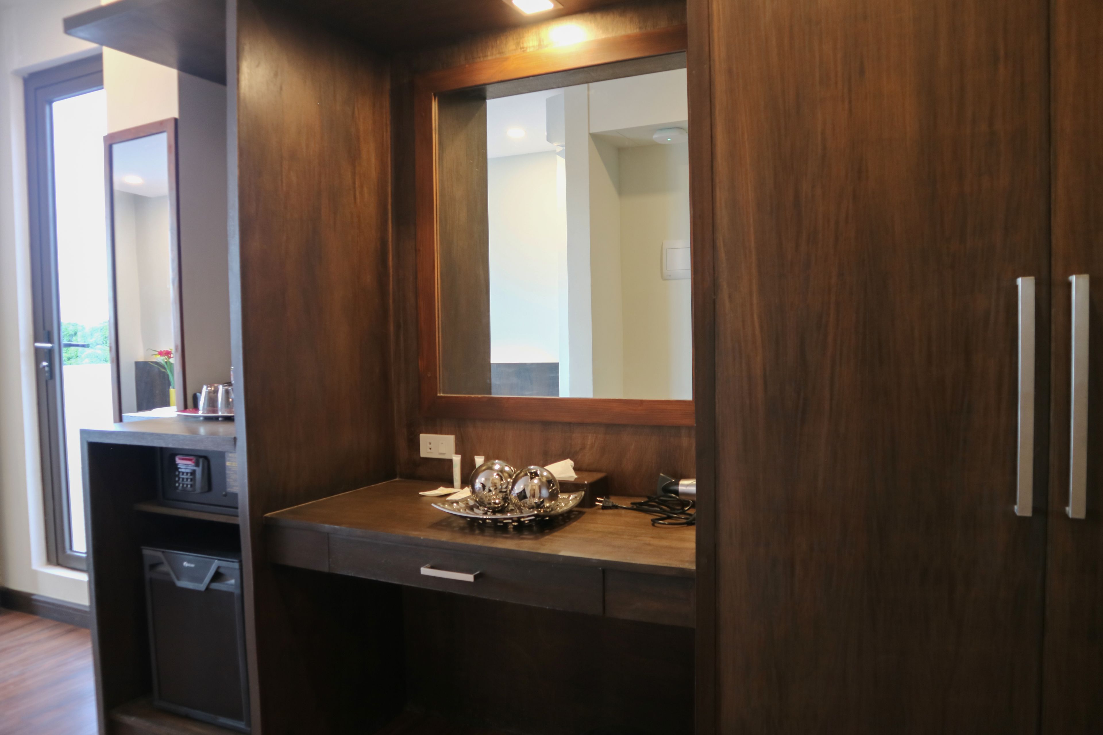 A bathroom with a wooden vanity, a mirror, and a sink.