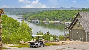 A lakeside property with a golf cart, docked boats, and a cabin with a dock. - Cabin #7 Table Rock Lake WATER FRONT Oasis Retreat, Sleeps 10! (Kimberling City)
