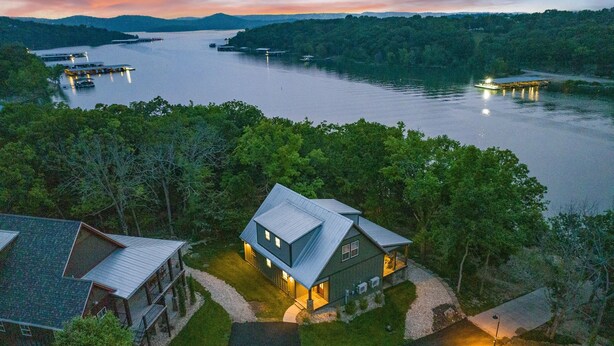 A lakeside property with a main house and a guest house, surrounded by dense forest and docked boats. - Cabin #7 Table Rock Lake WATER FRONT Oasis Retreat, Sleeps 10! (Kimberling City)