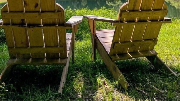 Two Adirondack chairs facing a lake with a forested hill in the background under a clear blue sky. - The Cottage - 2 miles to I-65 (Montevallo)