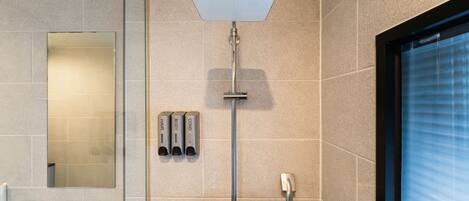 A modern bathroom with a shower, a mirror, and a window.