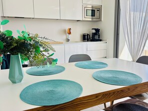A modern kitchen with a microwave, coffee maker, and a plant on the counter.