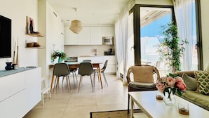 Un salon moderne avec un canapé, une table basse et un coin repas.