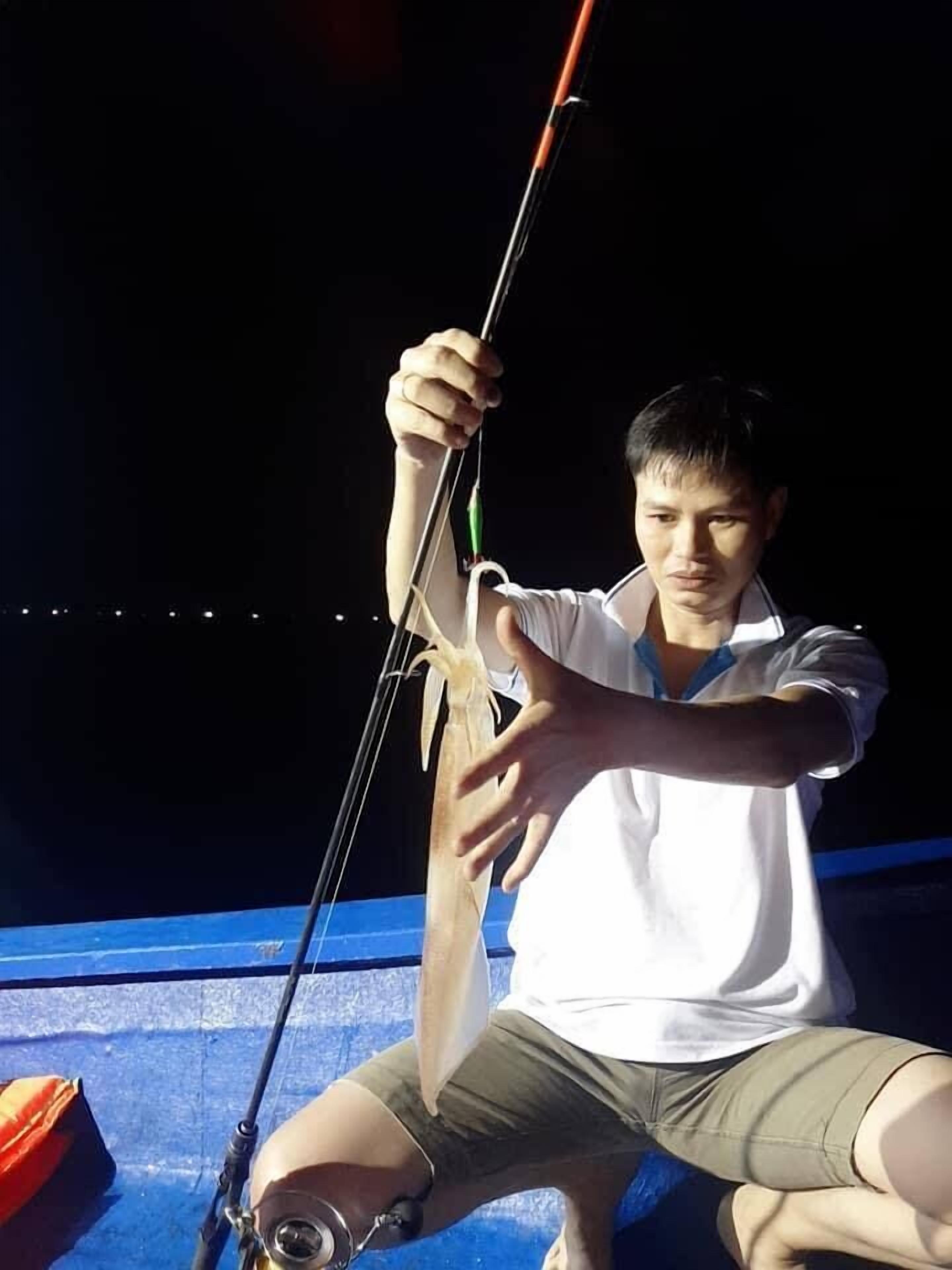 Una persona sosteniendo un arco y una flecha, sentada sobre una superficie azul con una bolsa a un lado.