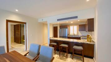A modern kitchen with a marble countertop, stainless steel appliances, and a bar area.