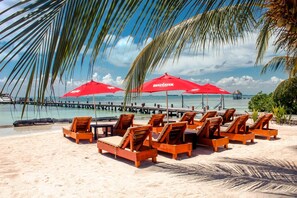 On the beach, white sand, sun-loungers, beach umbrellas