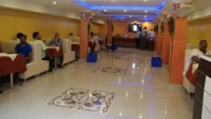 A hotel lobby with seating areas, a reception desk, and a decorative floor pattern. - Hotel Prakash Palace (Varanasi)