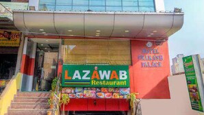 A hotel building with a large glass facade and a sign for LAZAWAB Restaurant at the ground level. - Hotel Prakash Palace (Varanasi)