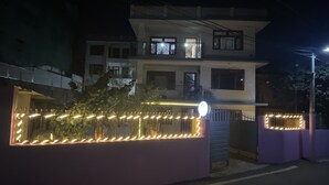 A multi-story building with a gated entrance, illuminated by decorative lights. - Nirvaan Guest House (Kathmandu)