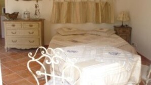 A bedroom with a bed, a dresser, a nightstand, and a mirror on the wall. - Charming cottage located in the heart of a Provencal farmhouse and its winery (Le Plan du Castellet)