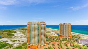 Dos hoteles de gran altura con balcones, acceso directo a la playa y una vista despejada del océano.