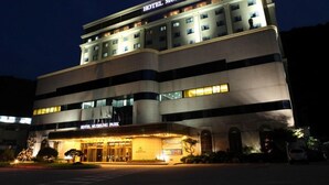 Un hotel de varios pisos con una entrada destacada y señalización que dice "HOTEL MUDEUNG PARK".