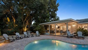 A swimming pool with lounge chairs and a covered patio area.
