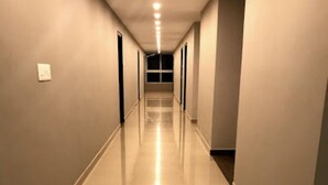Un passadís llarg i estret amb un sòl brillant i il·luminació empotrada.
