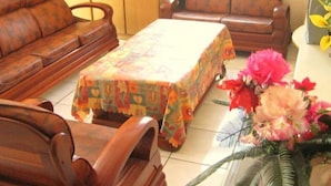 Een woonkamer met een bank, een salontafel en een bloemstuk.