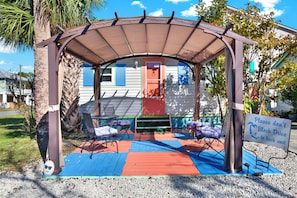 Relax in a shaded seating area with lounge chairs and a colorful mat.
