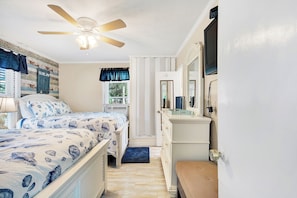 Cozy retreat with a nautical-themed bed, dresser, and mirror.