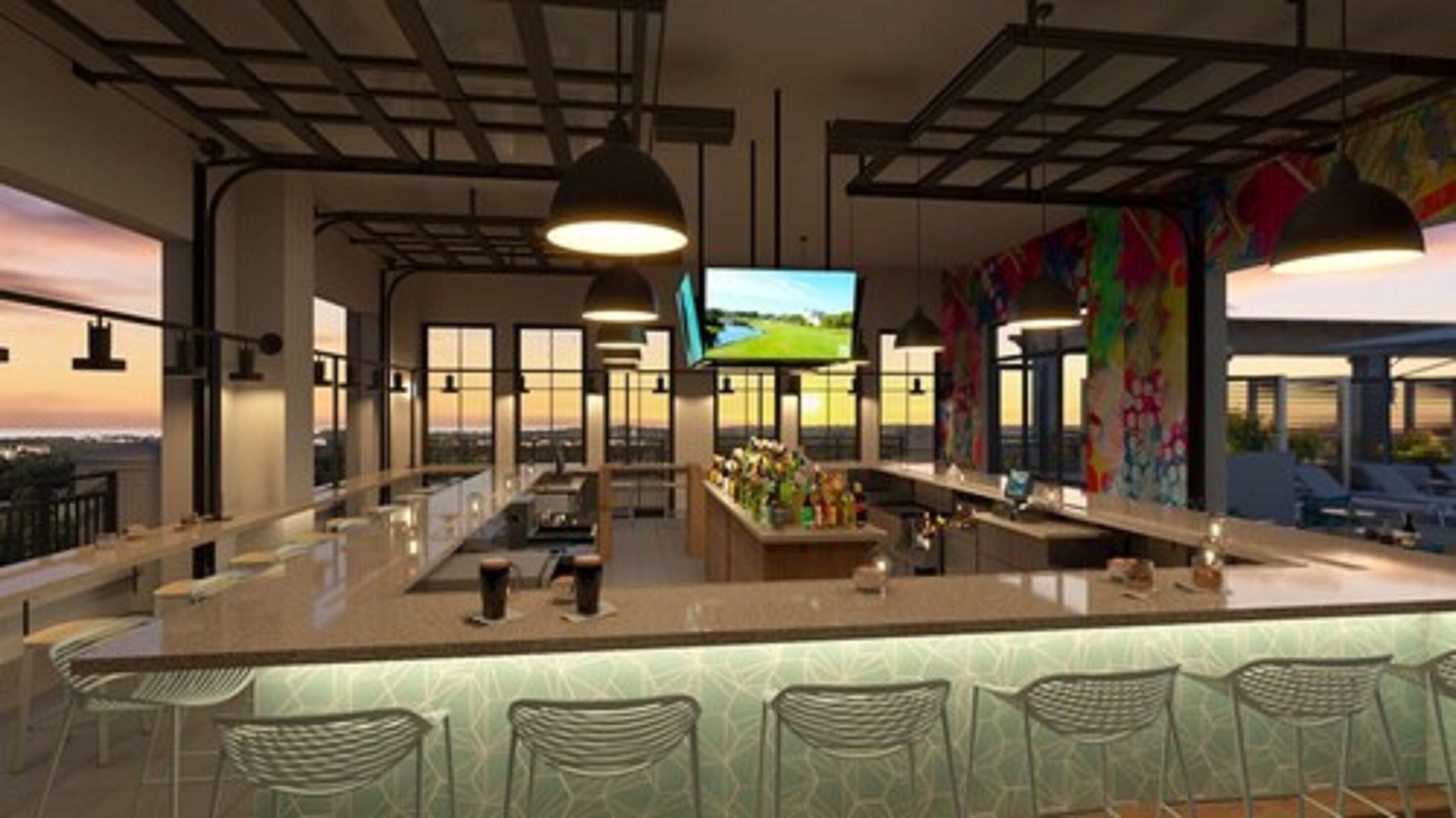 A modern bar area with a long counter, multiple hanging lights, and a large screen displaying a landscape.