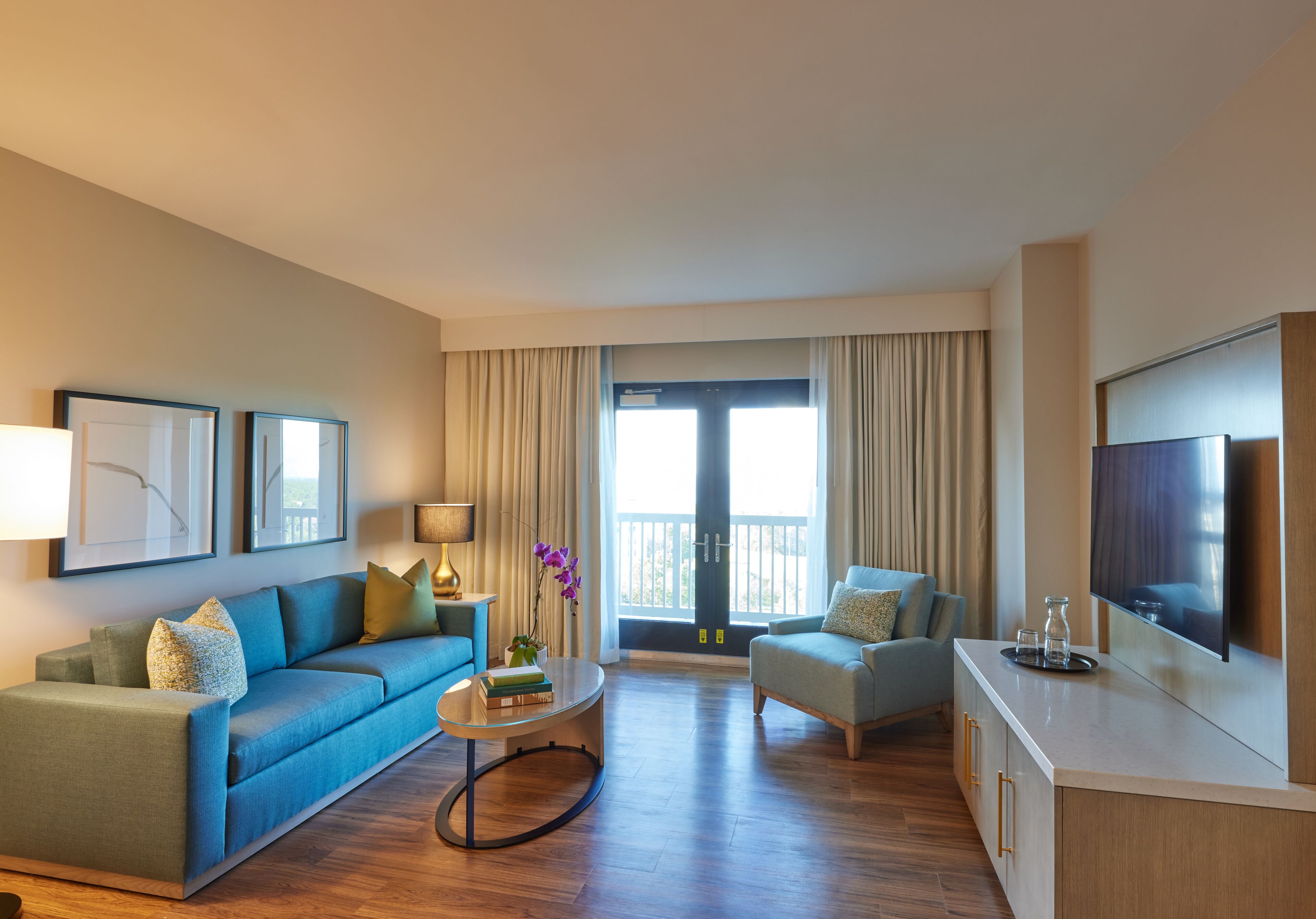 Ein modernes Wohnzimmer mit Sofa, Sessel, Couchtisch und Fernseher.