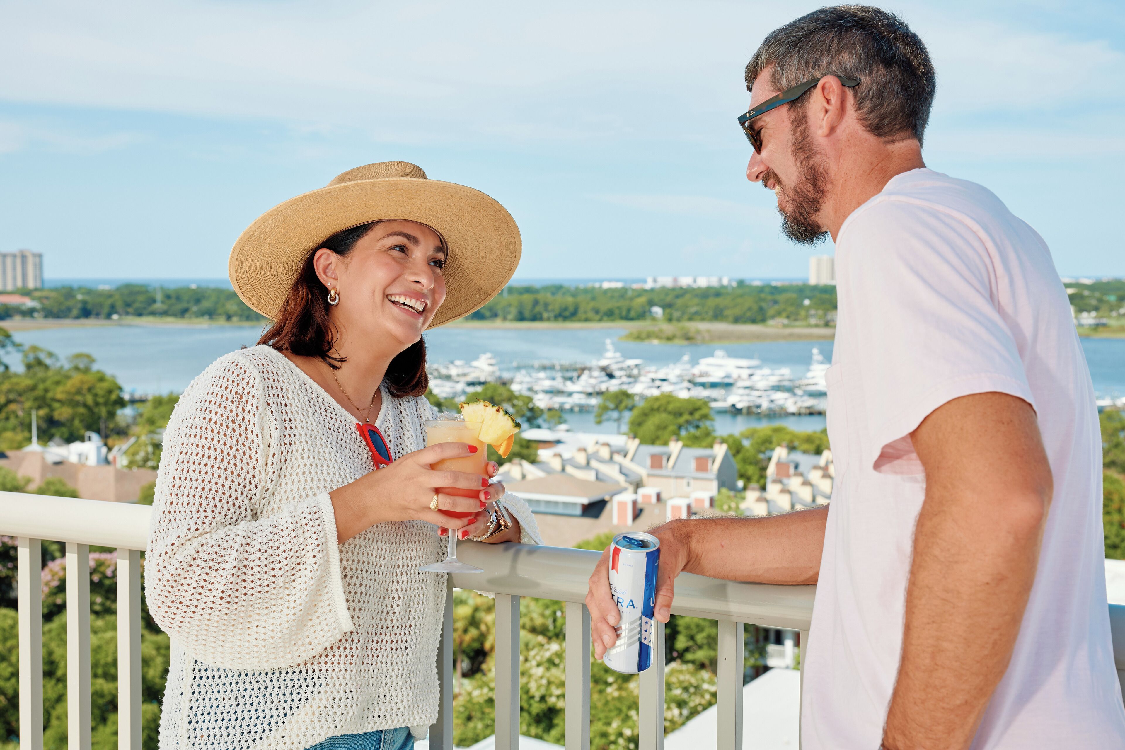 A balcony with a view of a marina and buildings across the water.