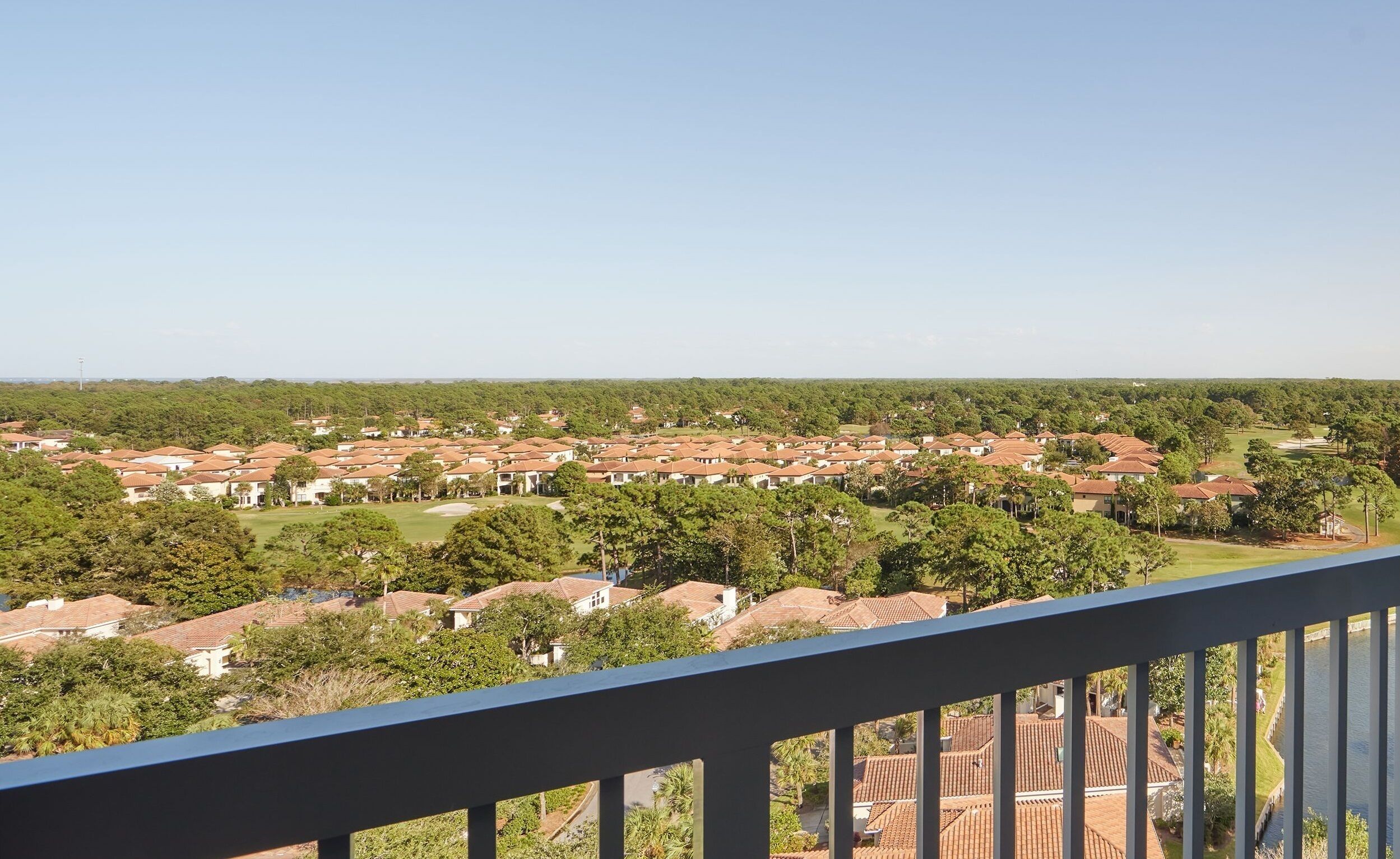 A residential area with multiple houses, green lawns, and a clear sky.