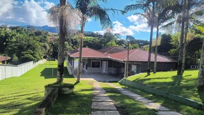 A house with a red roof, surrounded by lush greenery and palm trees. - Beautiful farm with swimming pool, a small island. Near the Rio Jaguari Waterfall. (Extrema)