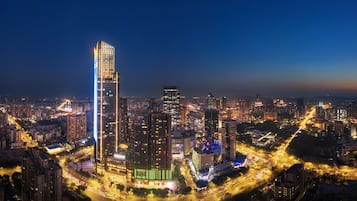 Un edificio de gran altura con varios pisos, rodeado de otros edificios y calles.